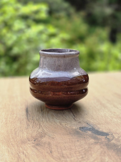 Vintage Keramikvase in Braun und Grau, frontal fotografiert mit runder Form und weichem grünem Hintergrund