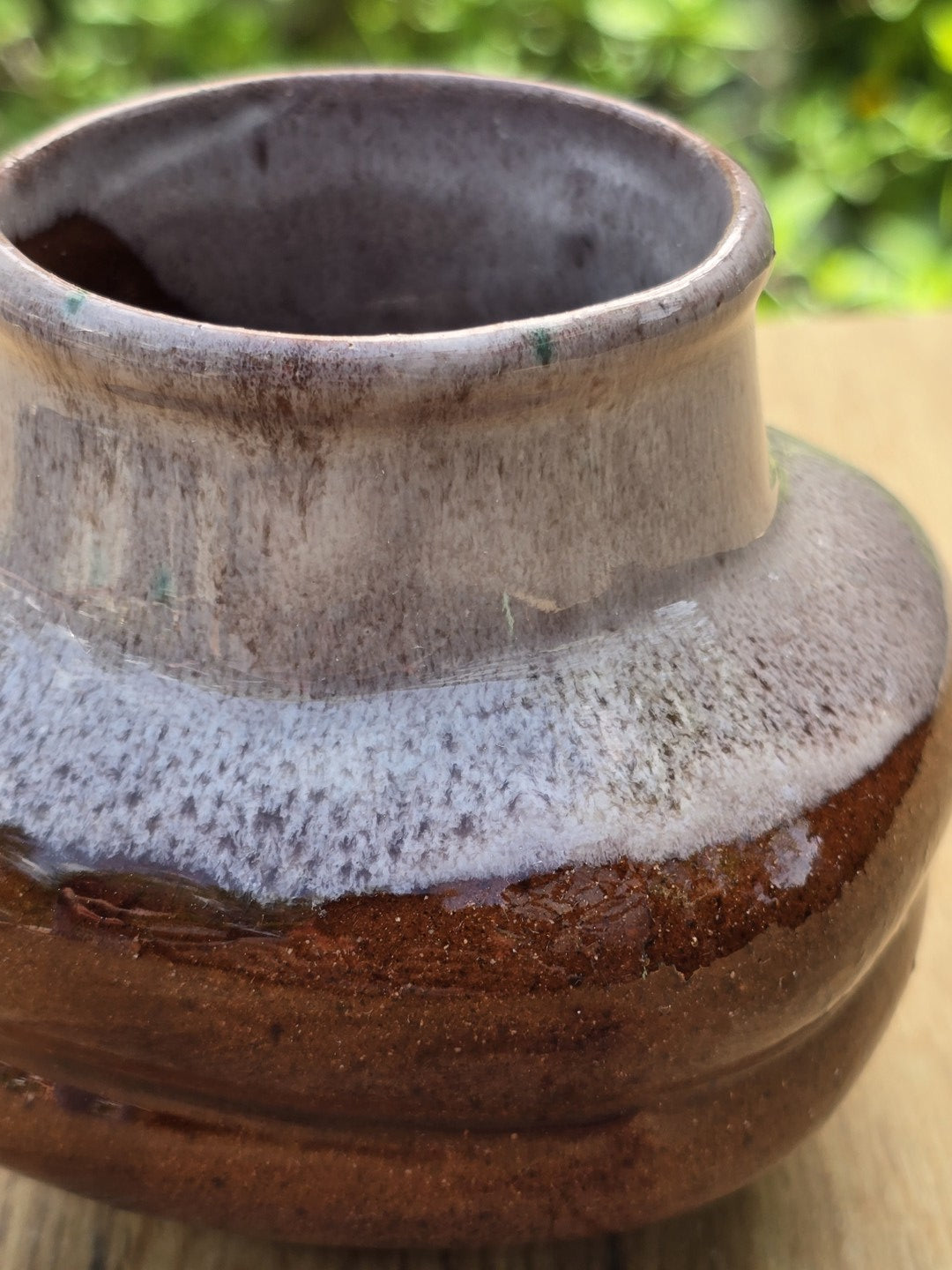 Makroaufnahme der braunen und grauen Glasur einer Vintage Keramikvase mit Struktur, Glanz und Gebrauchsspuren