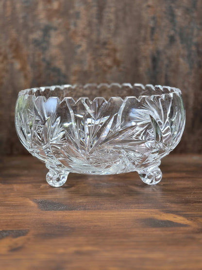 Klare Vintage Kristallglasschale mit geschliffenen Blatt- und Sternmotiven, gezacktem Rand und drei kleinen Glasfüßen.