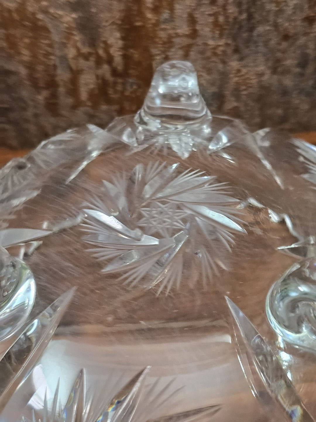 Detailaufnahme eines fein geschliffenen Sternmotivs mit strahlenförmigen Linien an der Wand der klaren Kristallglasschale.