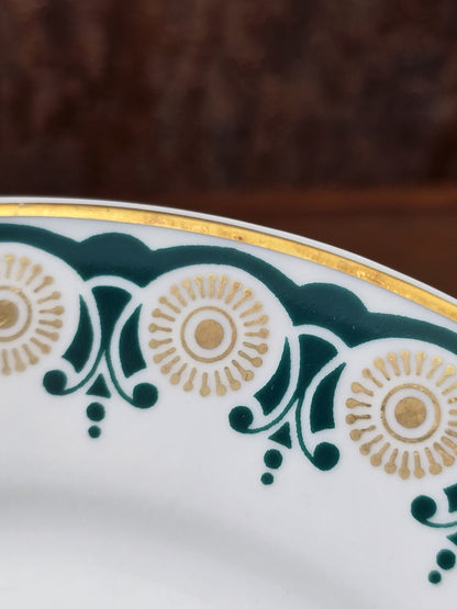 Vintage Porzellanteller mit Goldrand, grünem Ornamentdekor und goldenen Kreisformen in naher Detailansicht