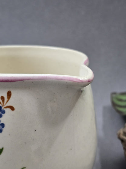 Nahaufnahme des Ausgusses mit geschwungenem rosa Rand, heller Keramikglasur und kleinen dunklen Punkten in der Oberfläche.
