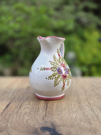 Kleiner Vintage-Krug aus glasierter Keramik mit bauchiger Silhouette, schmalem Hals, zartem Ausguss und handgemaltem Blumendekor in Rosa, Lila und Grün.