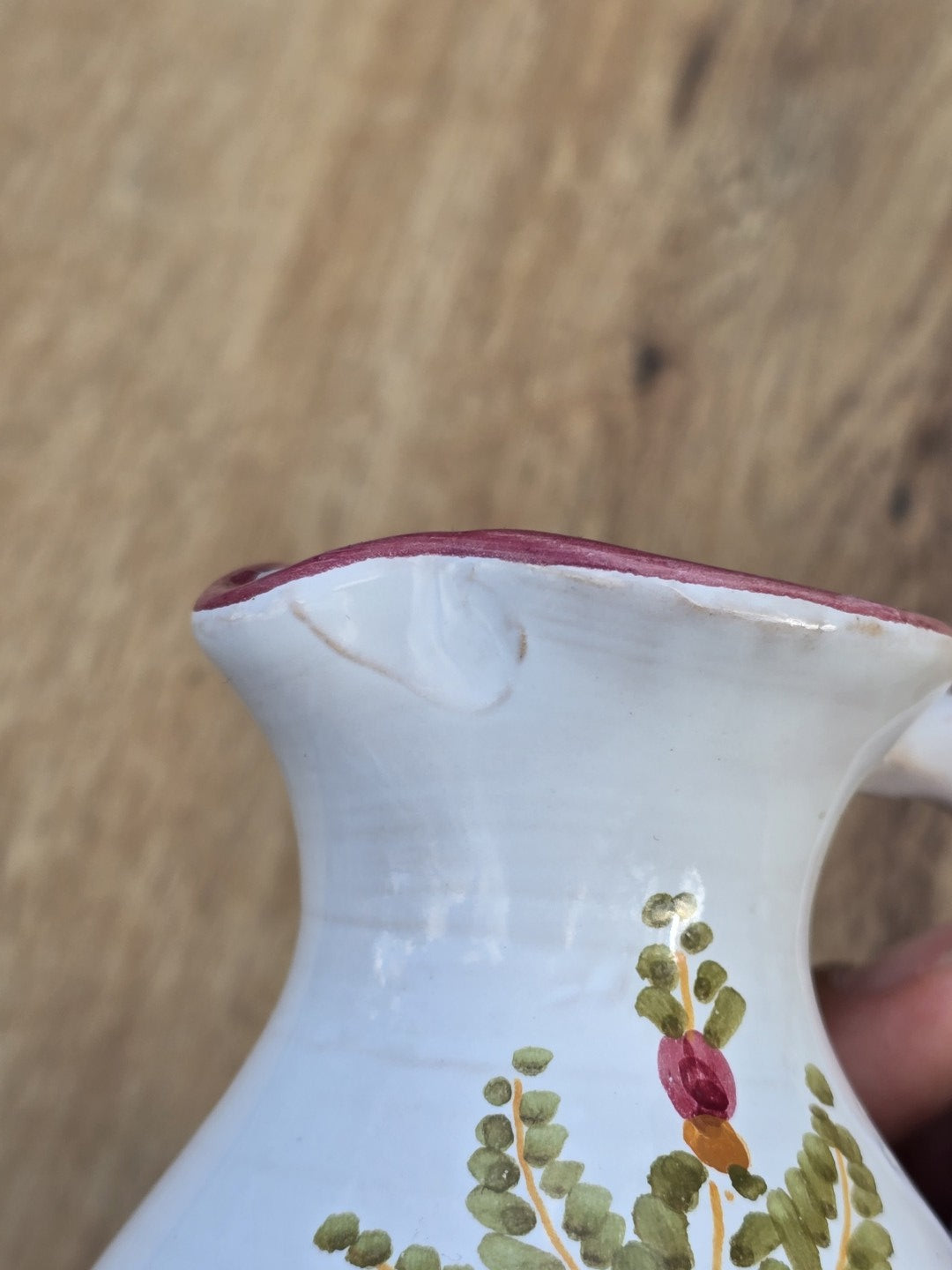 Mid-Century Keramikkrug im Kleinformat mit bauchiger Form, zartem Ausguss, handgemalter Blume und rosa Randakzent auf heller Glasur.