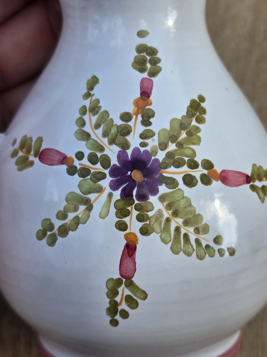 Dekorativer Vintage-Miniaturkrug aus Keramik mit floraler Handmalerei, zartem rosa Rand, kompakter Silhouette und herstellungsbedingten Lasurfehlern.