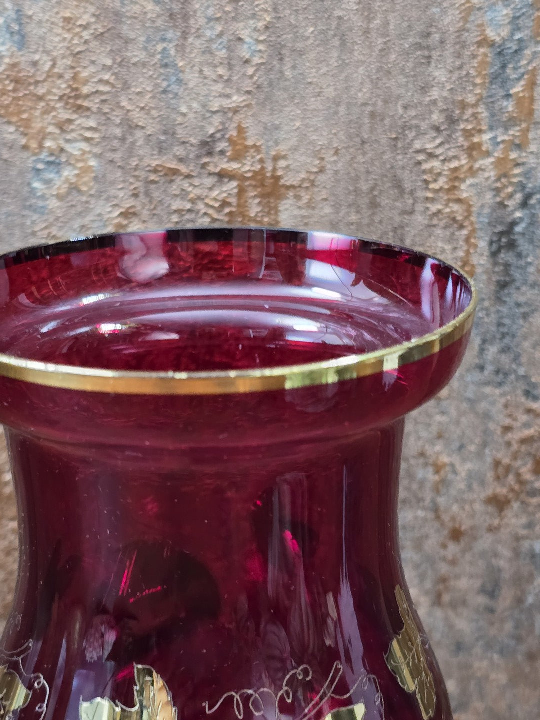 Rubinglas Pokal mit breitem Goldrand, dunkelrotem Glas und Weinlaubdekor in seitlicher Nahaufnahme