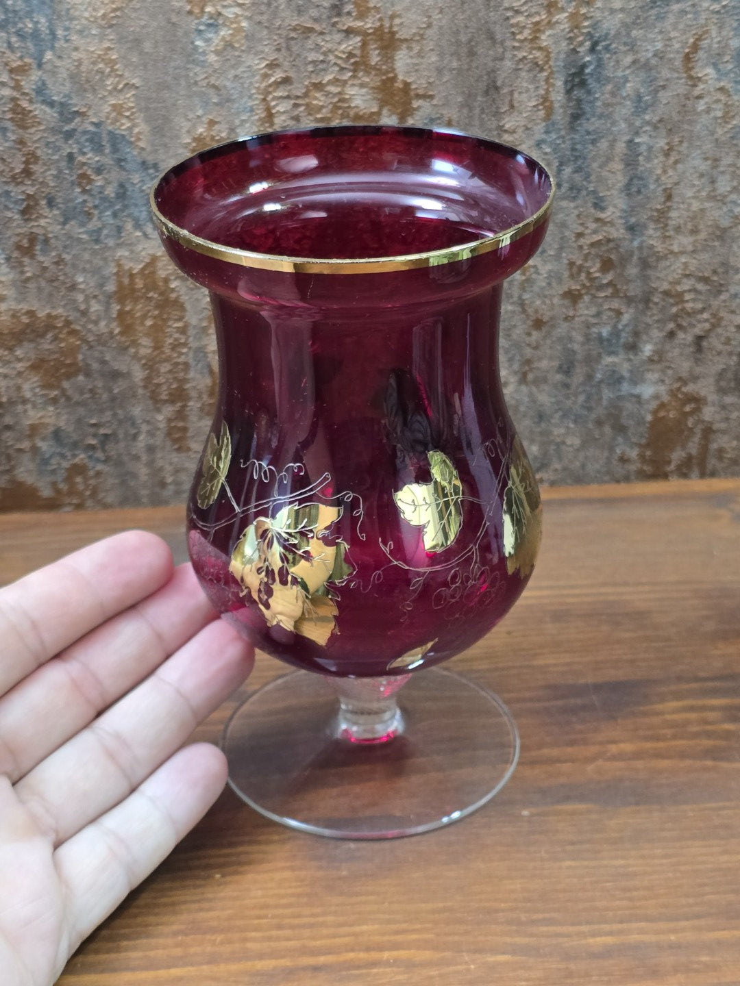 Rubinglas Pokal mit goldenen Weinblättern, Traubenlinien und klarem Fuß in frontaler Detailansicht