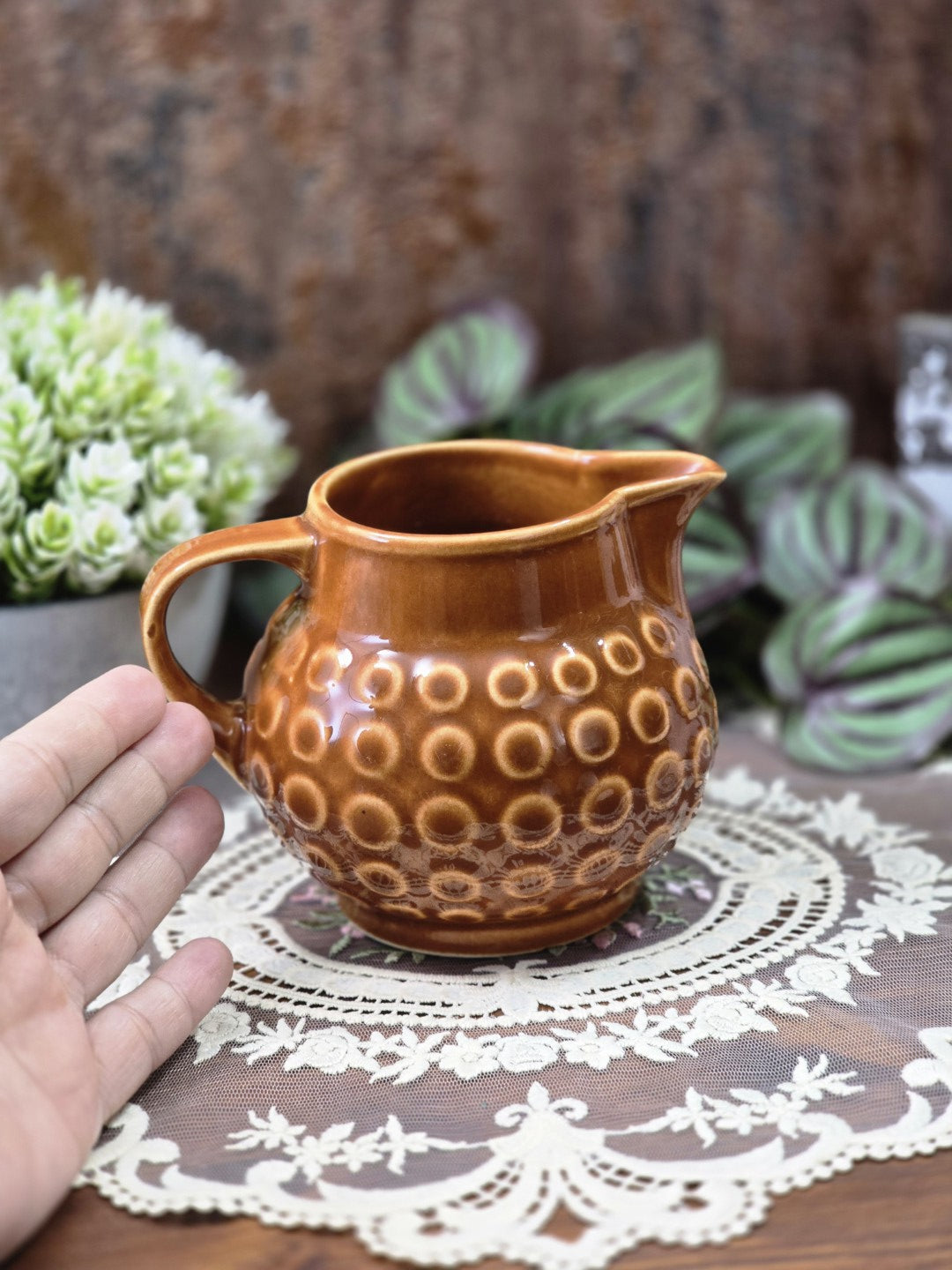Vintage Rusalka Milchkännchen mit brauner Glanzglasur, hellem Ringmuster und geschwungenem Henkel mit Hand als Größenvergleich