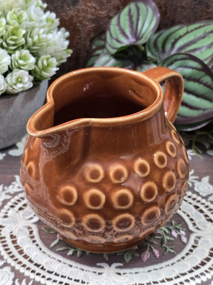 Vintage Keramik Milchkännchen mit brauner Glanzglasur, hellem Ringdekor und sichtbarem feinem Riss am Ausgussrand in Nahansicht