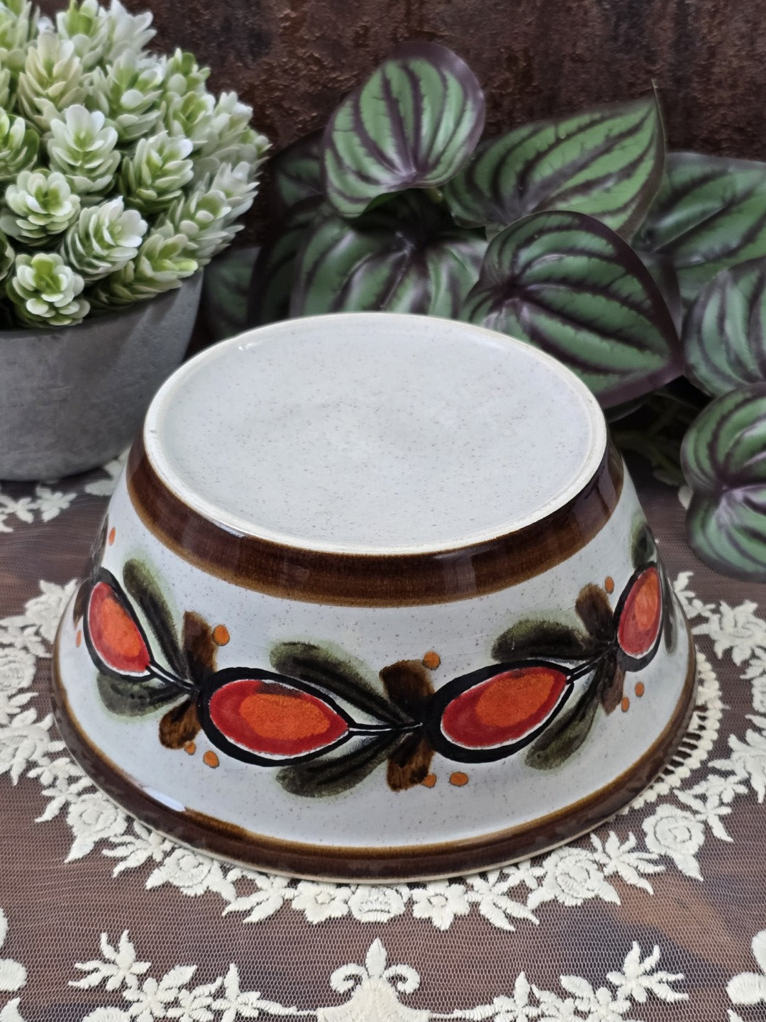 Vintage Keramikschüssel mit braunem Standring, hellem Boden und Hagebutten-Dekor auf der Außenseite von unten gezeigt