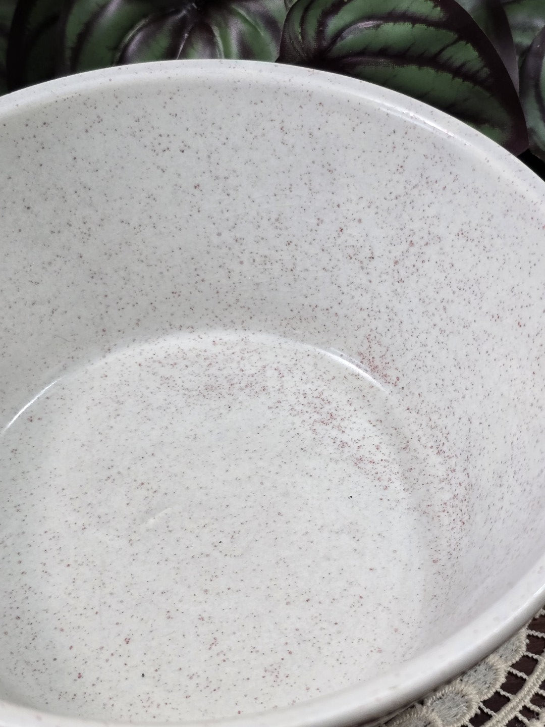 Vintage Keramikschüssel mit hellem gesprenkeltem Innenraum, runder Innenform und glatter Glasur in Detailansicht