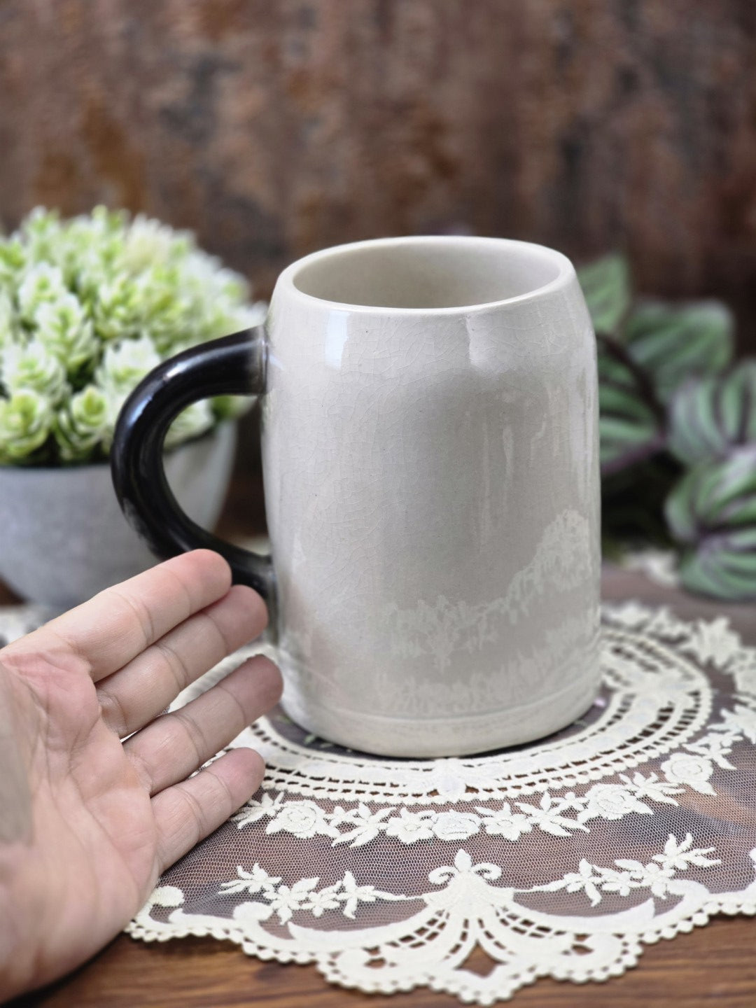 Vintage Sitzendorf Bierkrug mit grauer Craqueléglasur und dunkelgrauem Henkel, rückseitig mit Hand als Größenvergleich fotografiert