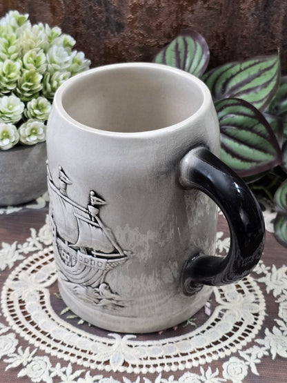 Vintage Sitzendorf Bierkrug mit plastischem Segelschiff-Relief, grauer Glasur und dunkel abgesetztem Henkel in schräger Seitenansicht