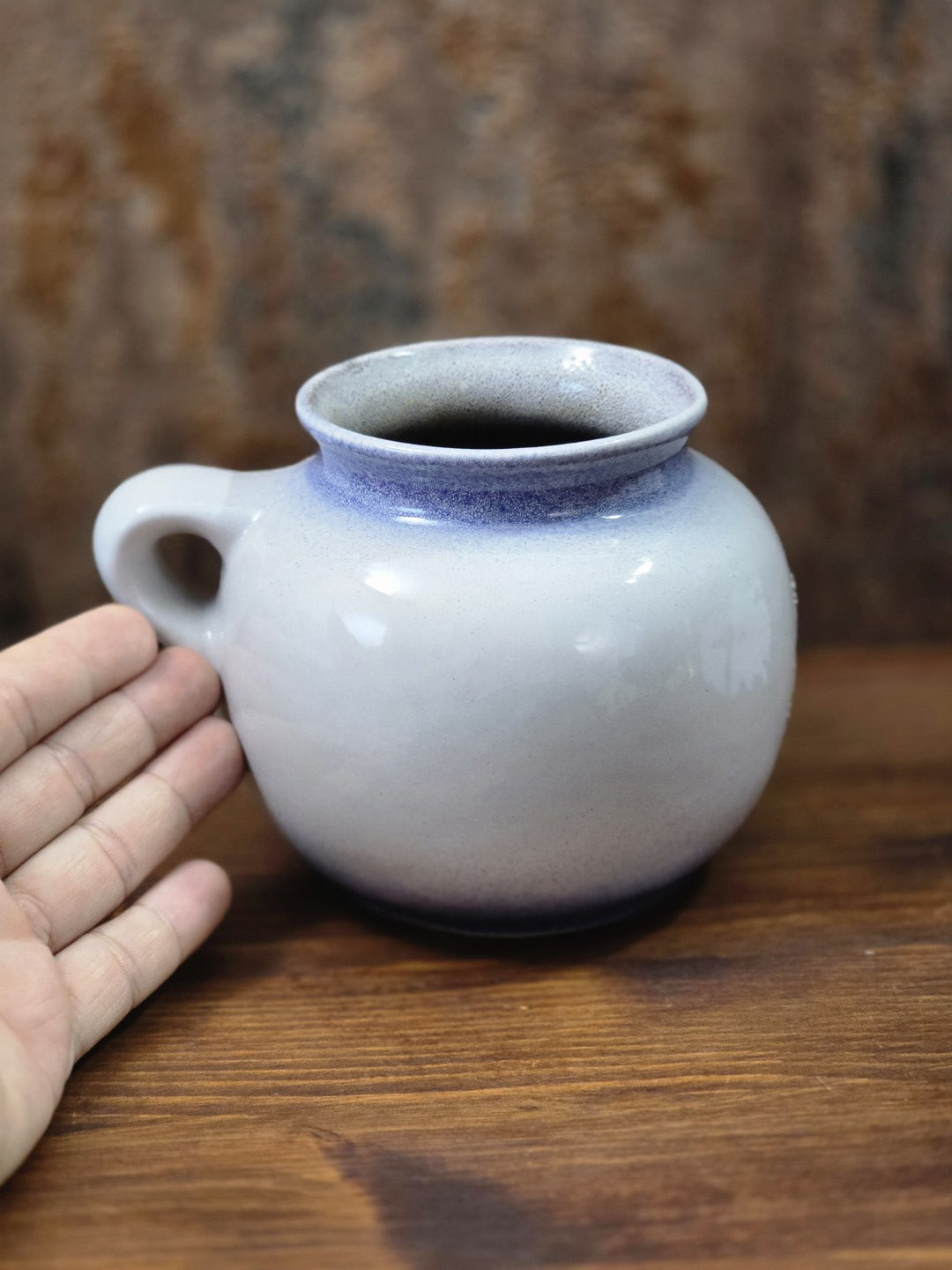 Vintage Strehla Keramikvase mit Henkel und blauem Fat-Lava-Blumendekor, fotografiert neben einer Hand als Größenvergleich