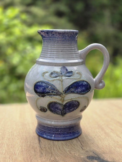 Graublauer Vintage Keramikkrug von Strehla mit kobaltblauem Fuß, Henkel und floralem Dekor in Blau und Violett.