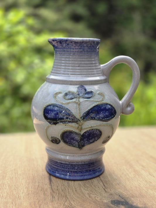 Graublauer Vintage Keramikkrug von Strehla mit kobaltblauem Fuß, Henkel und floralem Dekor in Blau und Violett.