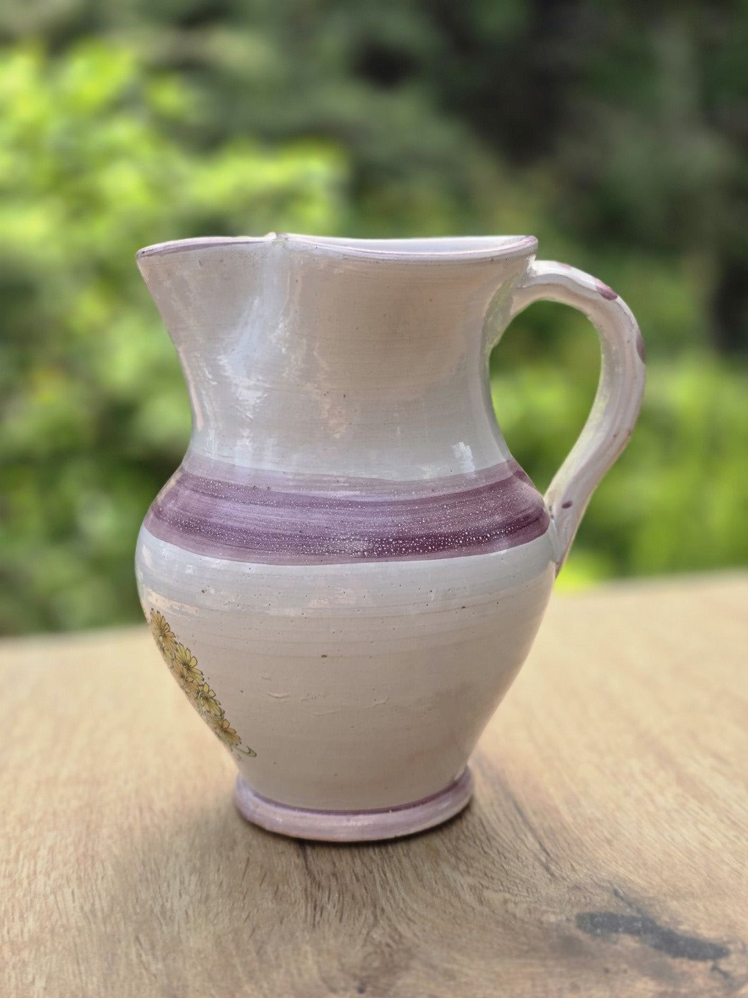 Vintage Studiokeramik Krug in Cremeweiß mit violettem Streifendekor, Henkel und gewelltem Ausguss auf Holzfläche.
