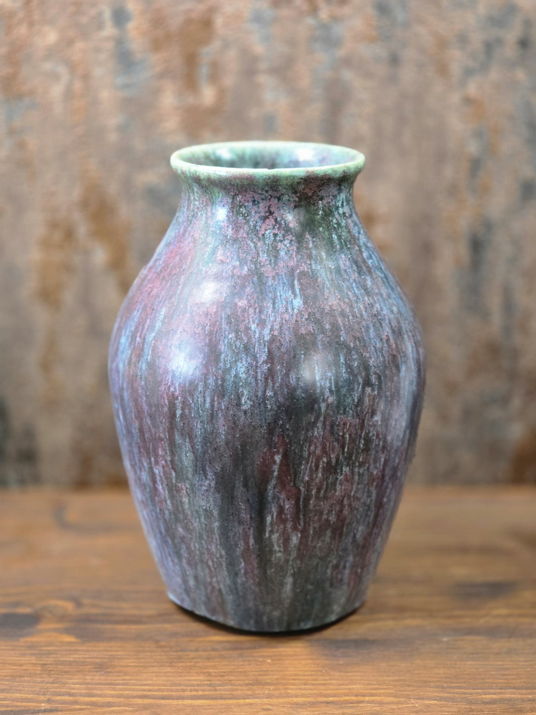 Vintage Studiokeramik-Vase mit bauchiger Form und verlaufender Glasur in Grün, Violett, Blau und Braun in frontaler Gesamtansicht.