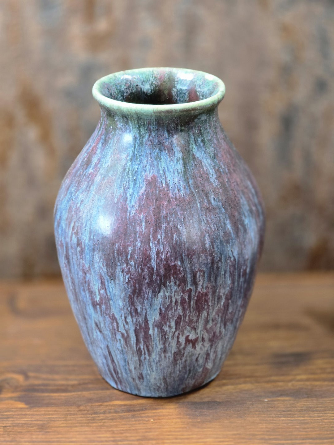 Vintage Keramikvase mit rundem Mündungsrand und lebhafter Glasur in Blau, Violett, Grün und Braun in leicht gedrehter Ansicht.