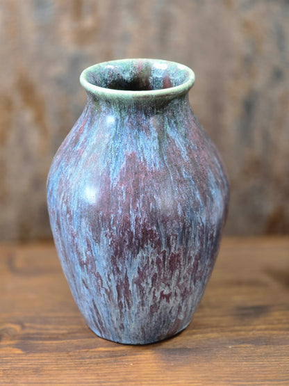 Vintage Keramikvase mit rundem Mündungsrand und lebhafter Glasur in Blau, Violett, Grün und Braun in leicht gedrehter Ansicht.