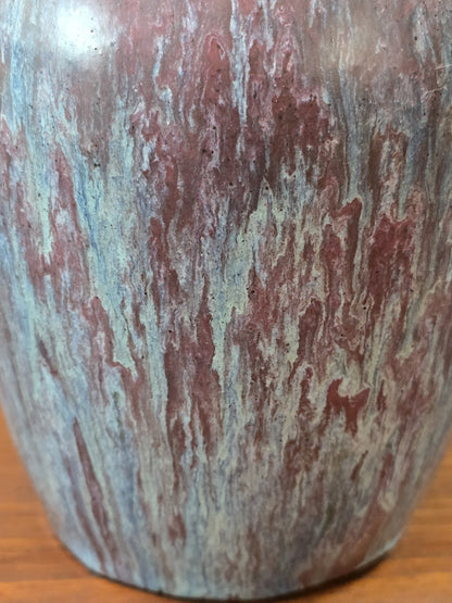 Vintage Keramikvase mit unregelmäßig verlaufender Glasur in Rosé, Hellblau und Grün in einer Detailaufnahme der Oberfläche.
