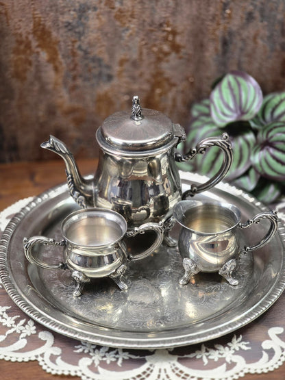 Vintage Teeservice versilbert mit Teekanne, Milchkännchen, Zuckerschale und Tablett auf Spitzendecke