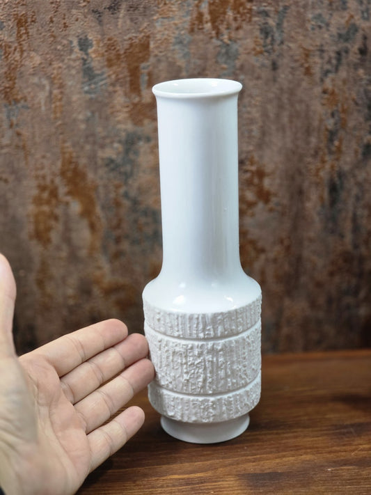 Vintage Thomas Porzellanvase mit weißer Glasur und strukturiertem Reliefdekor, neben einer Hand zur anschaulichen Größenwirkung fotografiert.