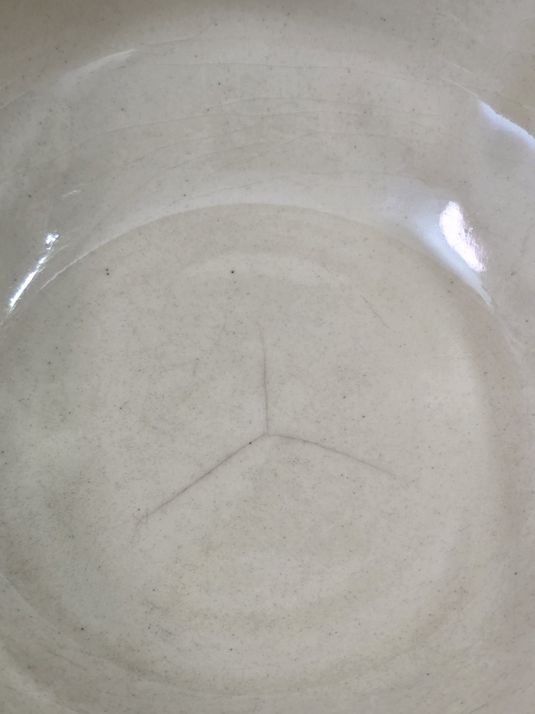 Vintage Steingutschüssel mit heller Innenfläche, feinen Gebrauchsspuren und glänzender Glasur in Innenansicht