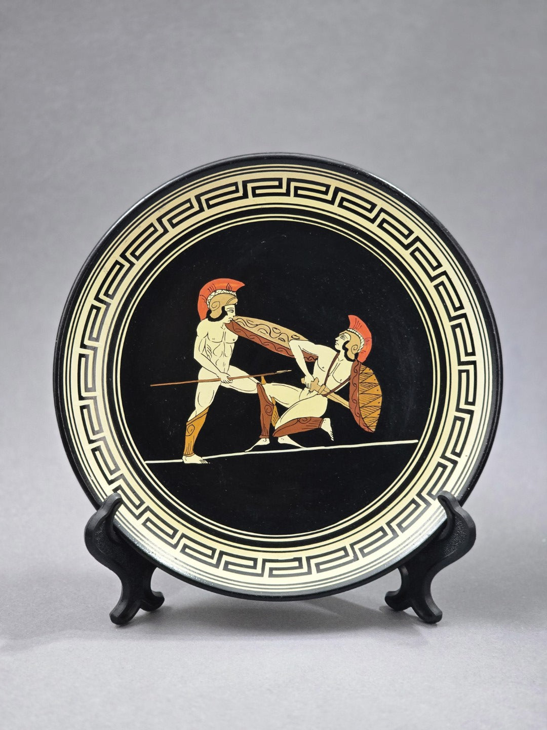 Vintage Wandteller mit griechischen Kriegern auf schwarzem Grund, umlaufendem Mäanderdekor in Creme und Frontalansicht