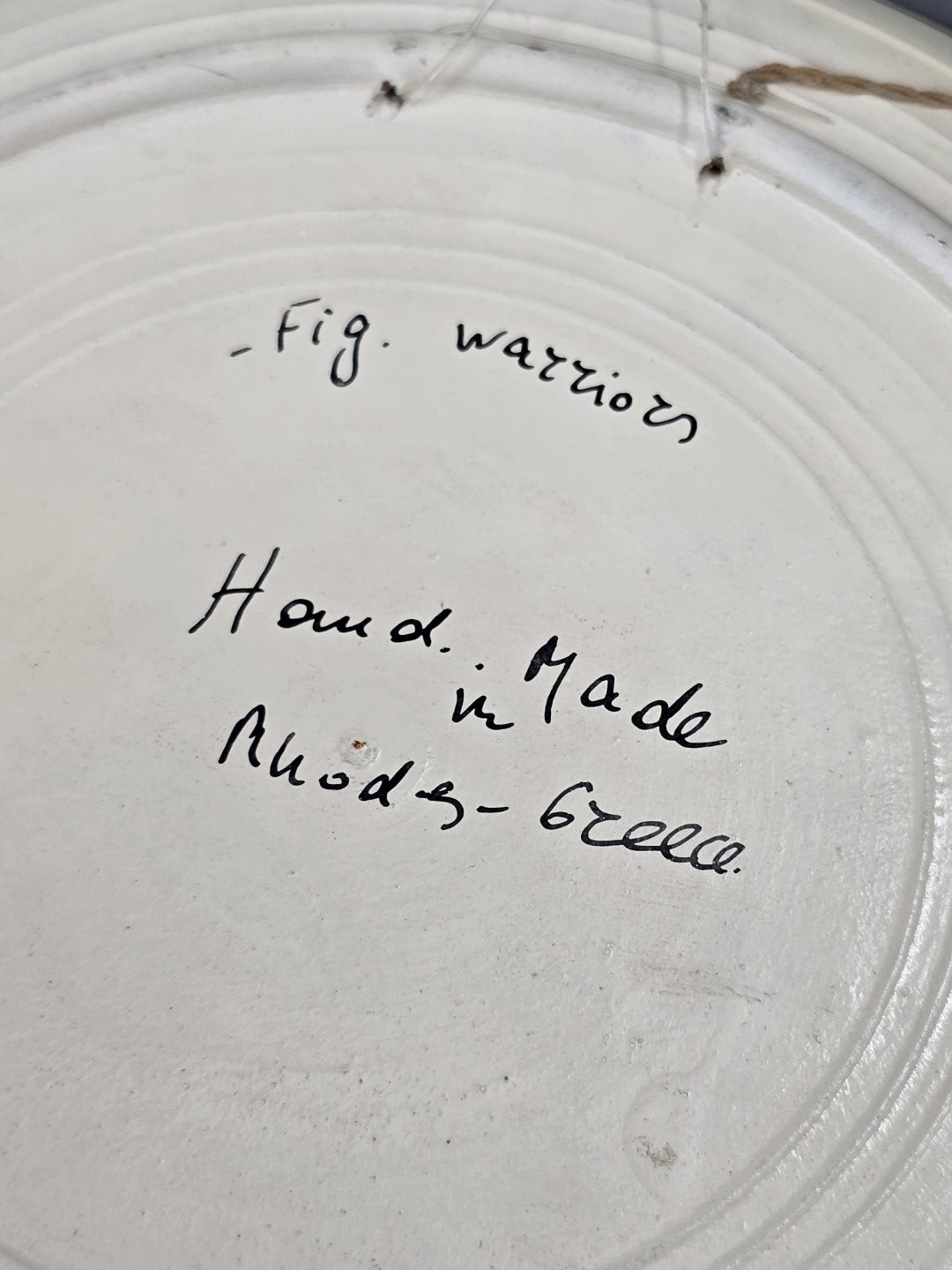 Vintage Wandteller mit handschriftlicher Beschriftung „Hand Made in Rhodos Greece“ auf der Rückseite in Nahaufnahme