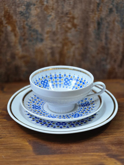 Vintage Weisswasser Porzellantasse mit Untertasse und Teller, blau-goldenem Kreisdekor und Goldrand auf Holztisch