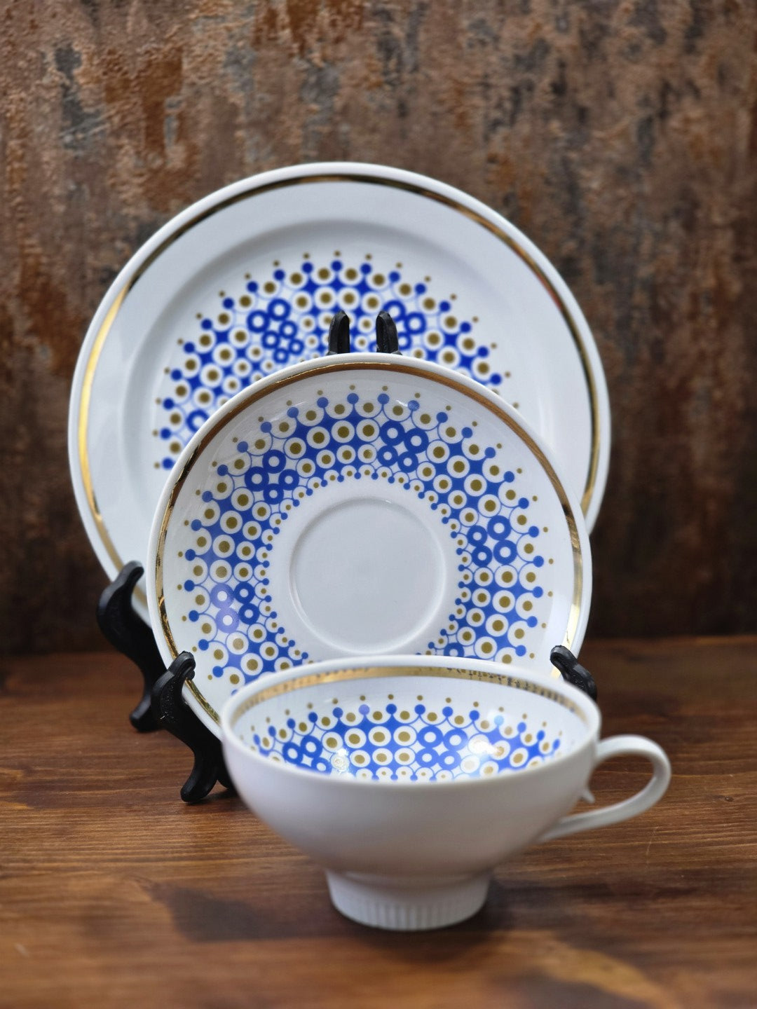 Vintage Weisswasser Porzellangedeck mit Tasse, Untertasse und Teller, blau-goldenem Dekor in gestellter Ansicht