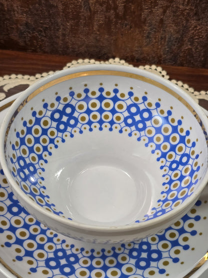 Vintage Porzellantasse mit blau-goldenem Innenranddekor und weißem Porzellan in naher Draufsicht