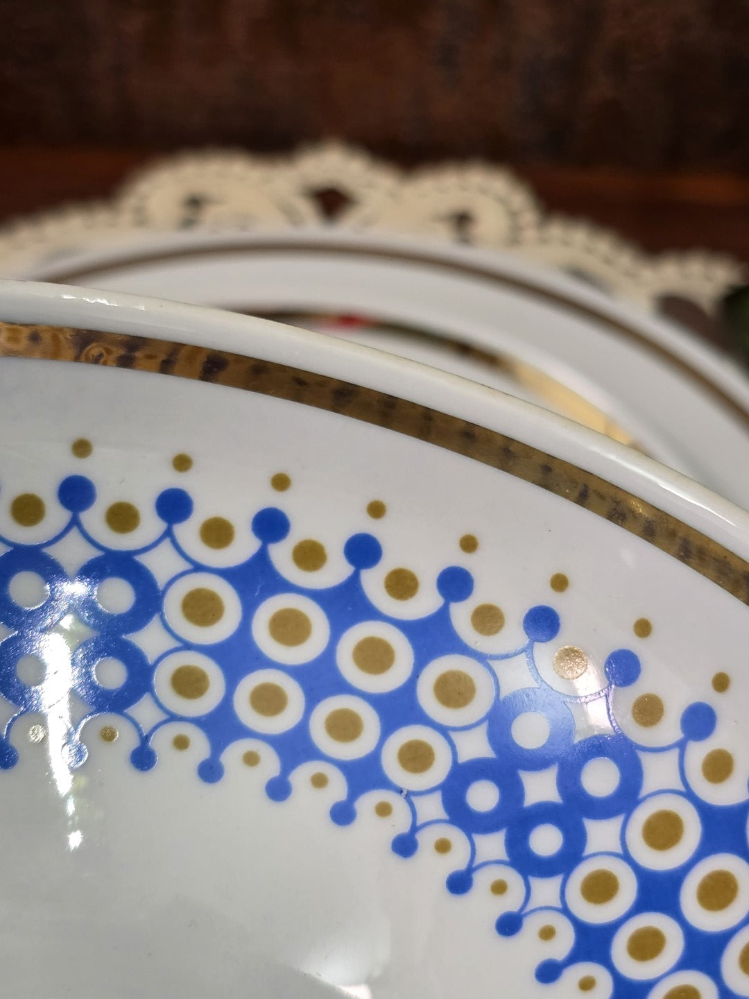 Vintage Porzellantasse mit blau-goldenem Kreisdekor und unregelmäßigem Goldrand in Detailaufnahme