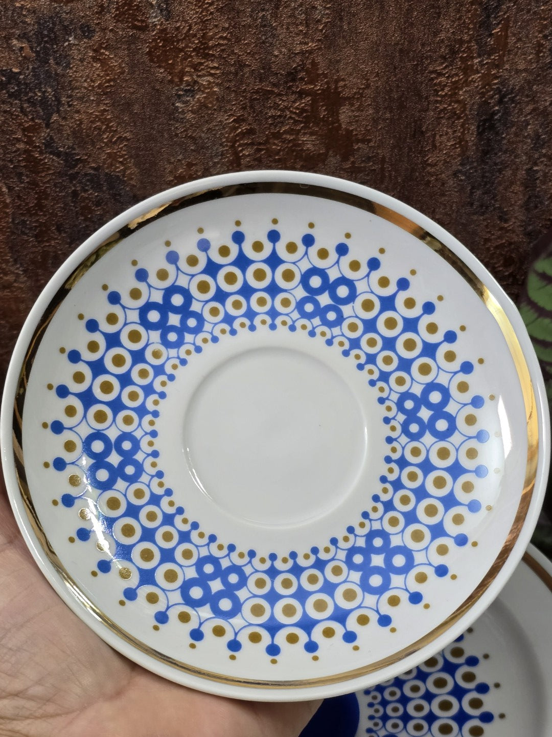 Vintage Porzellanuntertasse mit blau-goldenem Kreisdekor, Goldrand und weißer Mitte von oben fotografiert