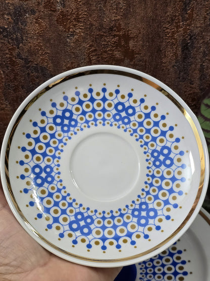 Vintage Porzellanuntertasse mit blau-goldenem Kreisdekor, Goldrand und weißer Mitte von oben fotografiert