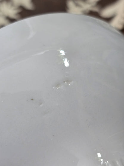 Vintage Porzellantasse mit weißer Glasur und kleinen sichtbaren Stellen im Inneren in Nahaufnahme