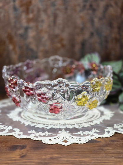 Vintage Pressglasschale mit floralem Relief, roten und gelben Blüten sowie klarem Glasrand auf Holztisch