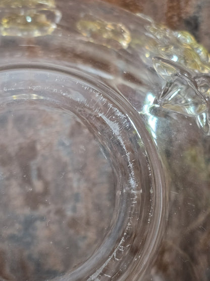 Vintage Glasschale mit sichtbaren Kratzern am runden Boden und floralem Relief am Rand in Detailaufnahme
