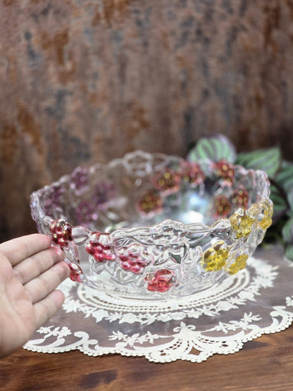 Vintage Glasschale mit buntem Blumenrelief, klarem Pressglas und Hand als Größenvergleich auf Spitzendecke