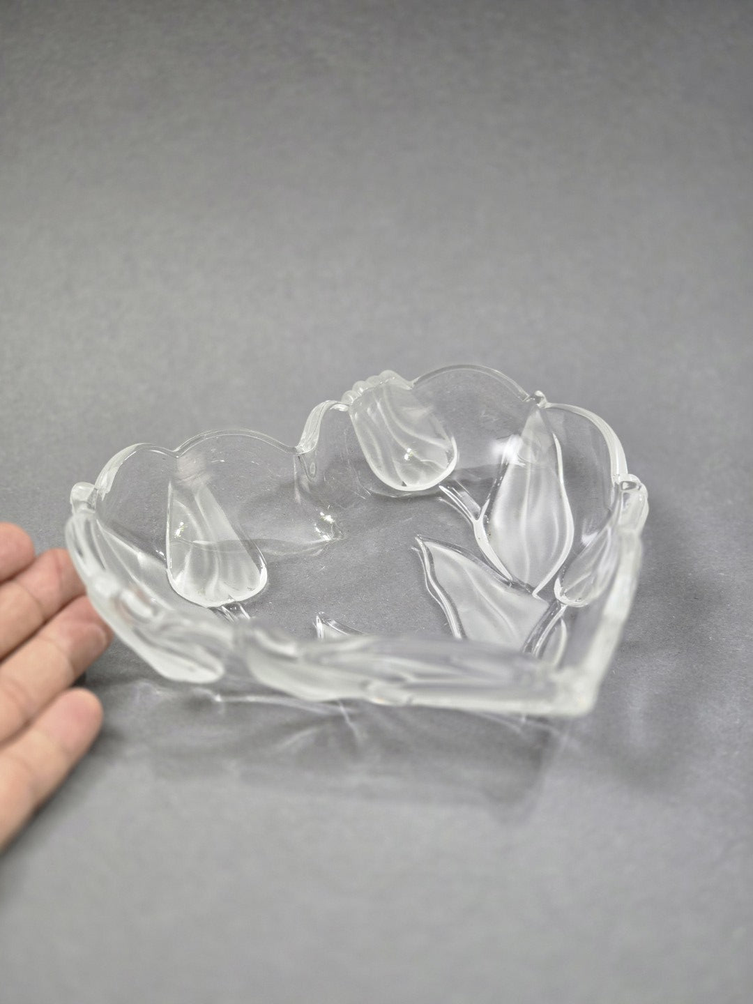 Vintage Walther Glasschale in Herzform mit plastischem Tulpendekor aus klarem und satiniertem Glas, mit Hand als Größenvergleich