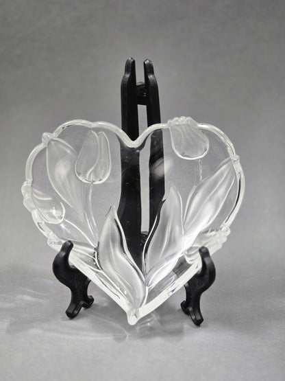 Vintage Walther Glasschale in Herzform mit Tulpen- und Blattrelief aus klarem Glas, frontal auf schwarzem Tellerständer gezeigt