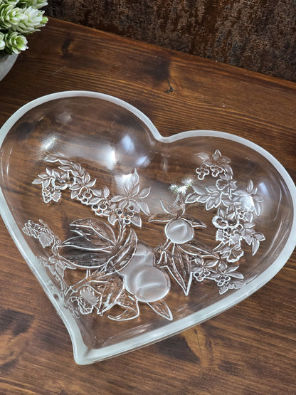 Vintage Glasschale in Herzform mit erhabenen Trauben, Blättern und glänzender Glasoberfläche als Nahaufnahme