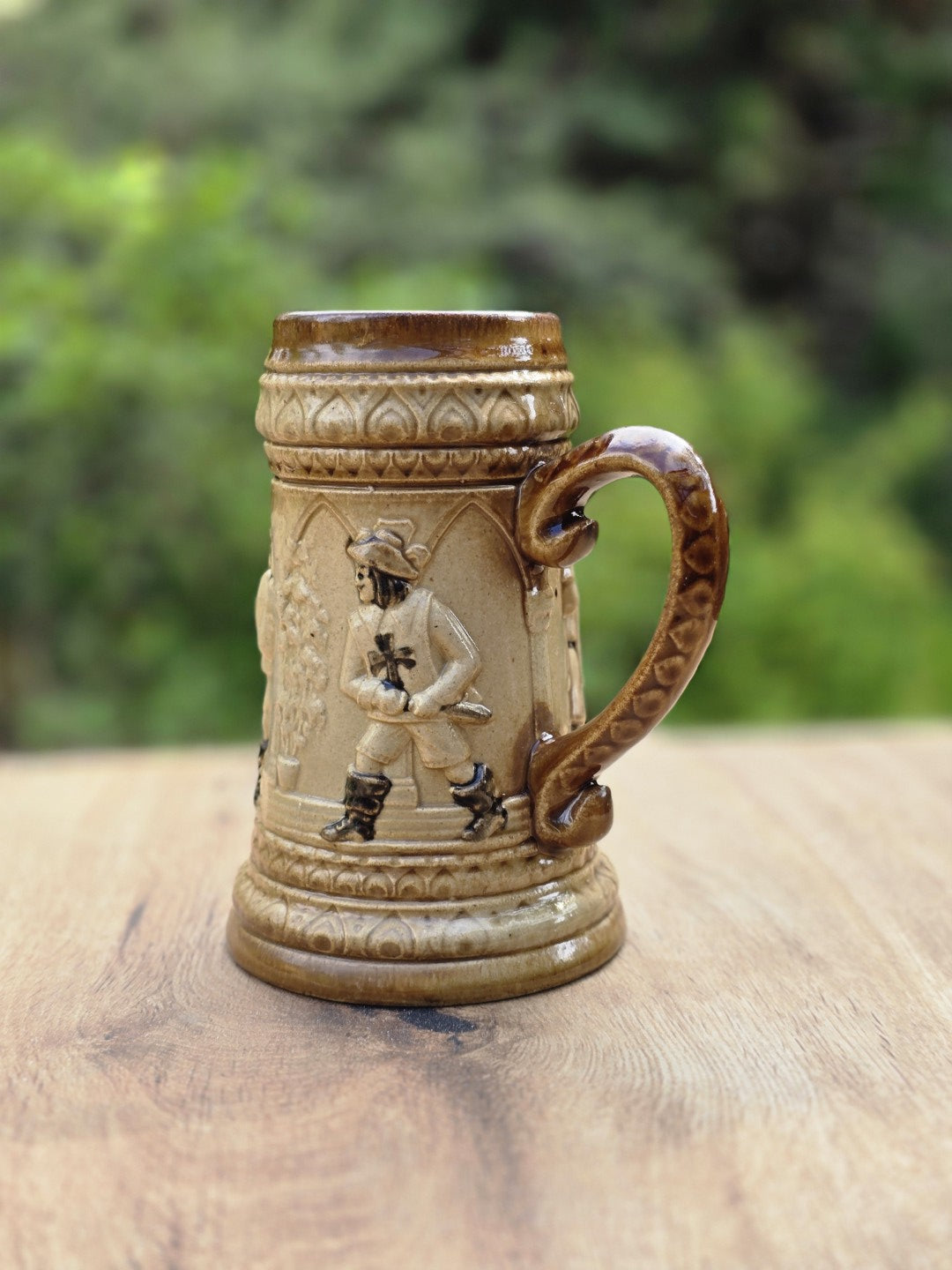 Vintage Westerwald Bierseidel in Braun-Beige mit plastischem Landsknecht Motiv, Tatzenkreuz, geschwungenem Henkel und kleinem Chip am Standring.