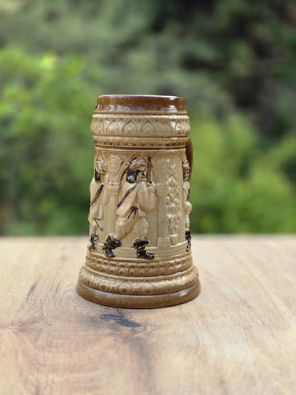 Westerwald Bierseidel mit braun-beiger Glasur, Landsknecht Figur im Relief, Tatzenkreuz auf der Brust und kleinem Chip am Standfuß.