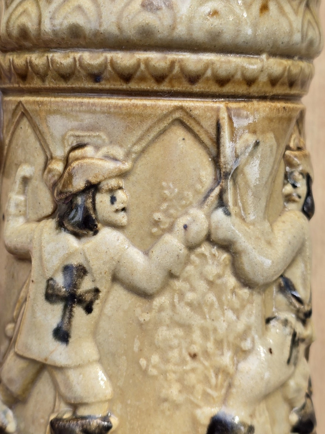 Historisierendes Westerwald Bierseidel in Braun und Beige mit Landsknecht Relief, Tatzenkreuz, gebogenem Henkel und kleinem Chip am Bodenrand.
