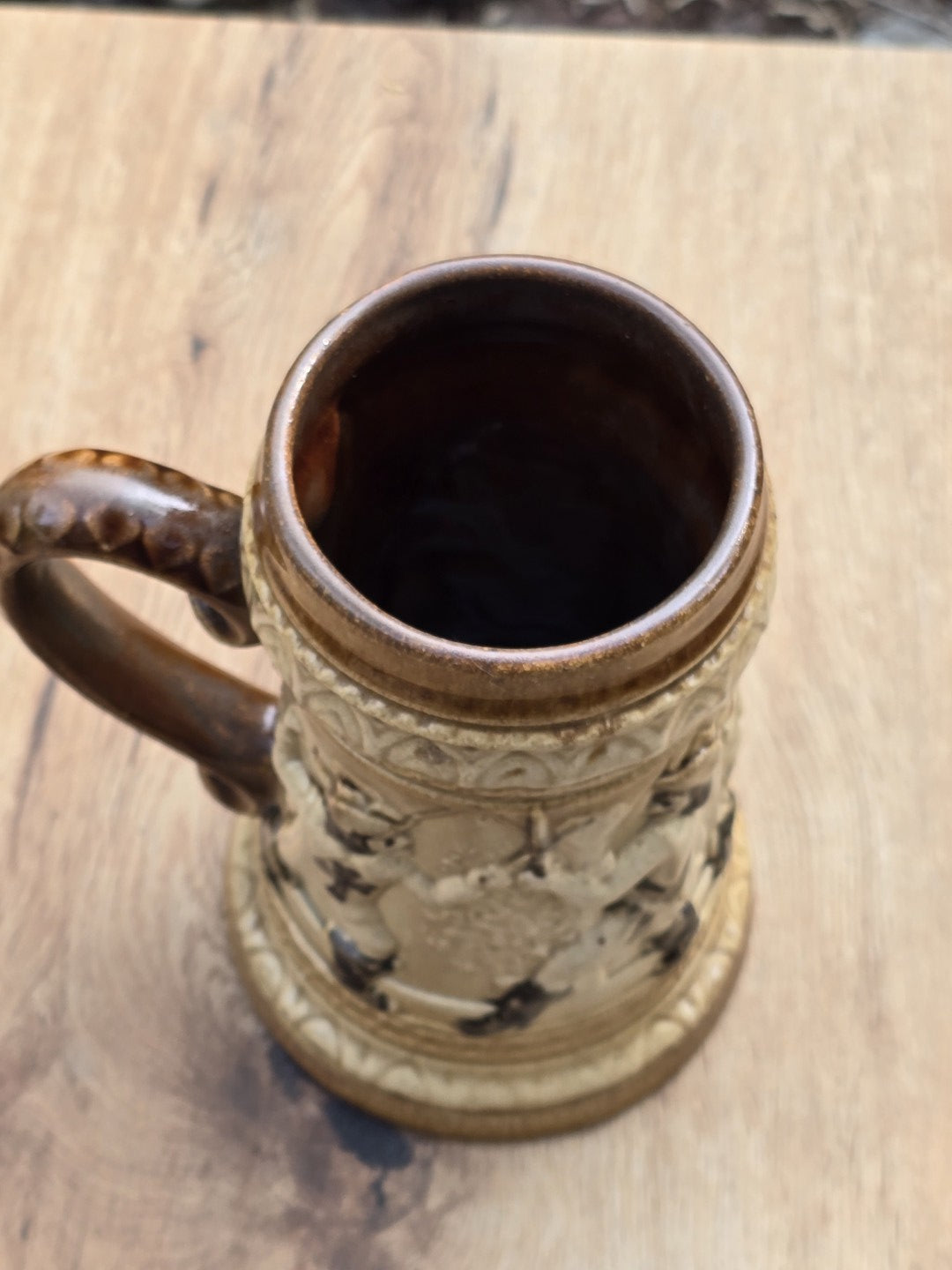 Braun-beiger Westerwald Bierkrug mit plastischem Landsknecht Dekor, Tatzenkreuz auf der Brust, geschwungenem Henkel und kleinem Chip am Standring.