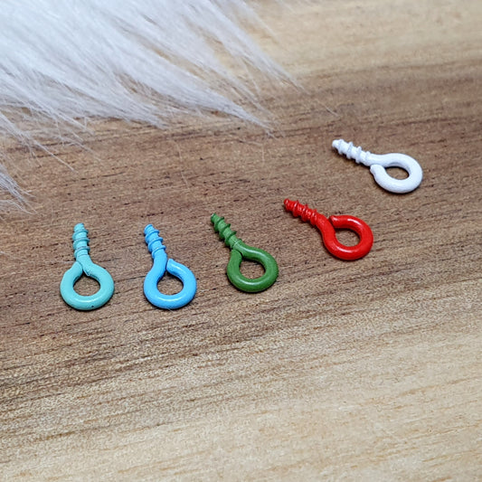 Das Bild zeigt ein Set von 10 farbig lackierten Schraubösen in verschiedenen lebhaften Farben, darunter Hellblau, Grün, Rot, Aqua, Weiß und Rosa. Jede Schrauböse hat die Abmessungen von ca. 8x4mm und ist sorgfältig gestaltet, um eine einfache Anwendung zu ermöglichen. Die Schraubösen sind ideal für das Einschrauben in Materialien wie Holz, Resin oder Acryl, um individuelle Anhänger zu kreieren. Die glänzende Oberfläche der Schraubösen sorgt für einen attraktiven Look, der jedem kreativen Projekt einen farbe