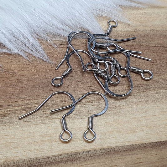 Das Bild zeigt ein Paar French Ohrhaken aus 304 Edelstahl in Silberfarbe. Die Haken haben eine elegante, geschwungene Form mit einer kleinen Öse am unteren Ende, die zur Befestigung von Anhängern oder Perlen dient. Die Oberfläche ist glatt und glänzend, was ihnen ein hochwertiges und modernes Aussehen verleiht. Mit einer Größe von etwa 16 mm sind sie ideal für die Gestaltung individueller Ohrringe.