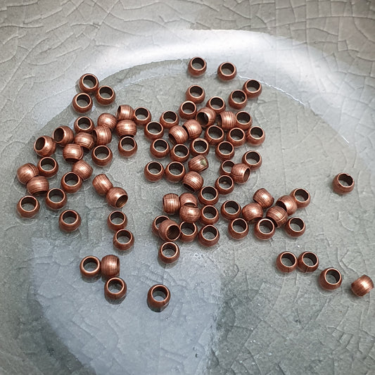 Das Bild zeigt Quetschperlen in Kugelform, antik kupferfarbig mit einem Durchmesser von 2,5mm. Ideal zum Fixieren von Perlen.